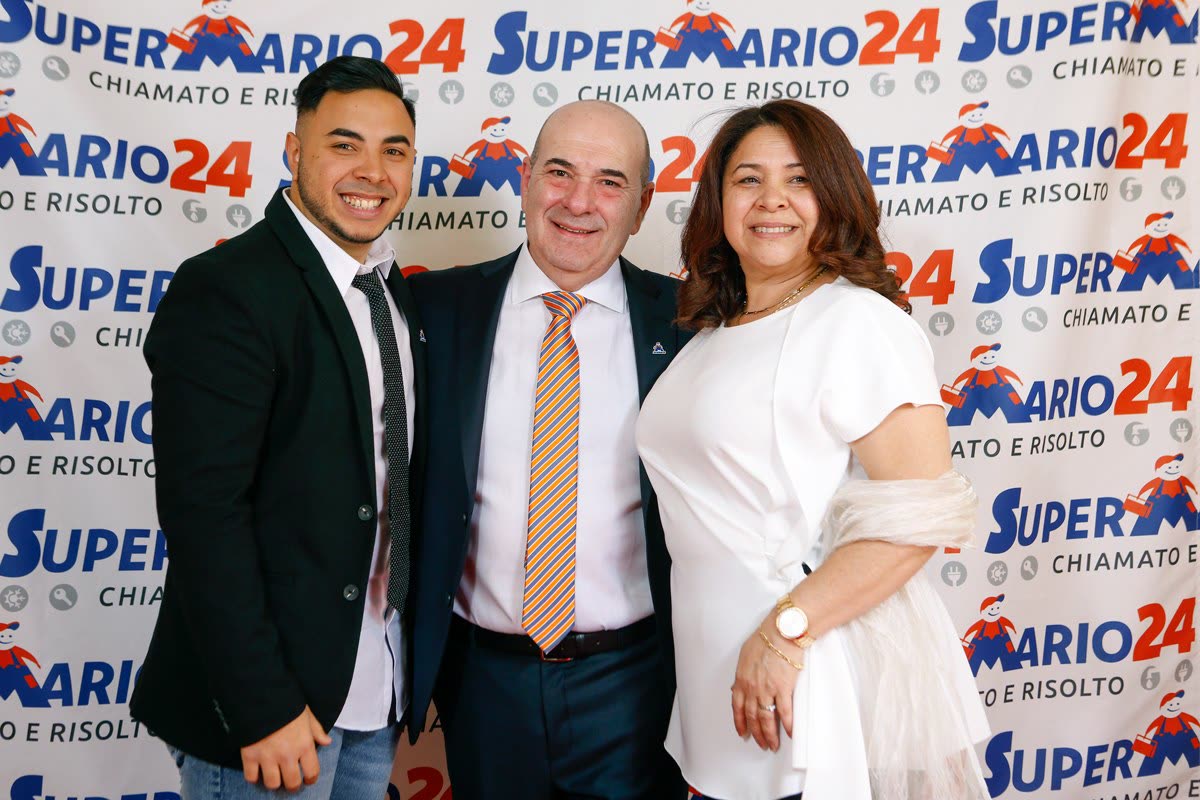 Mario e una collaboratrice davanti al fondale brandizzato Super Mario 24