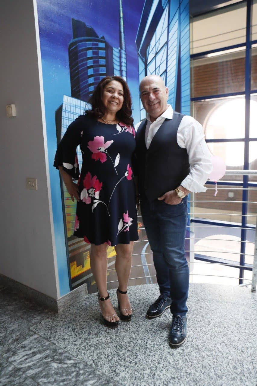 Mario e Mercedes insieme davanti a una parete blu