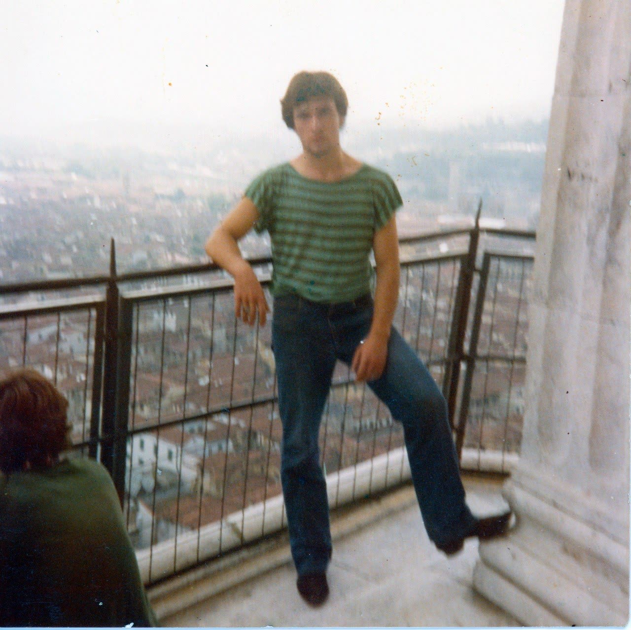 Fotografia d'archivio molto granulosa: Mario da giovane appoggiato a una ringhiera sulla città