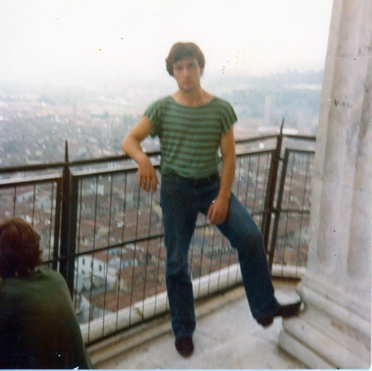 Fotografia d'archivio molto granulosa: Mario da giovane appoggiato a una ringhiera sulla città