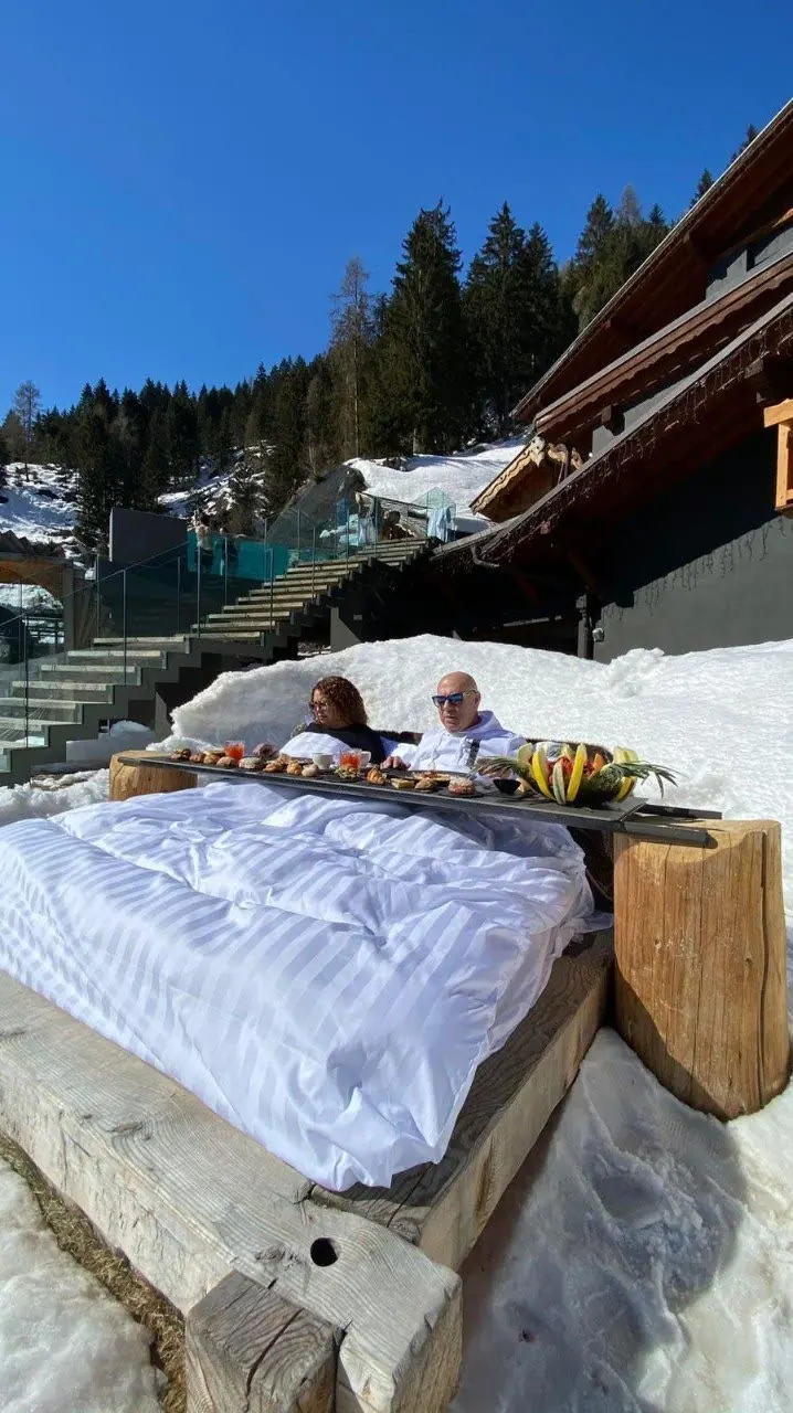 Mario e Mercedes fanno colazione all'aperto nella neve davanti a uno chalet