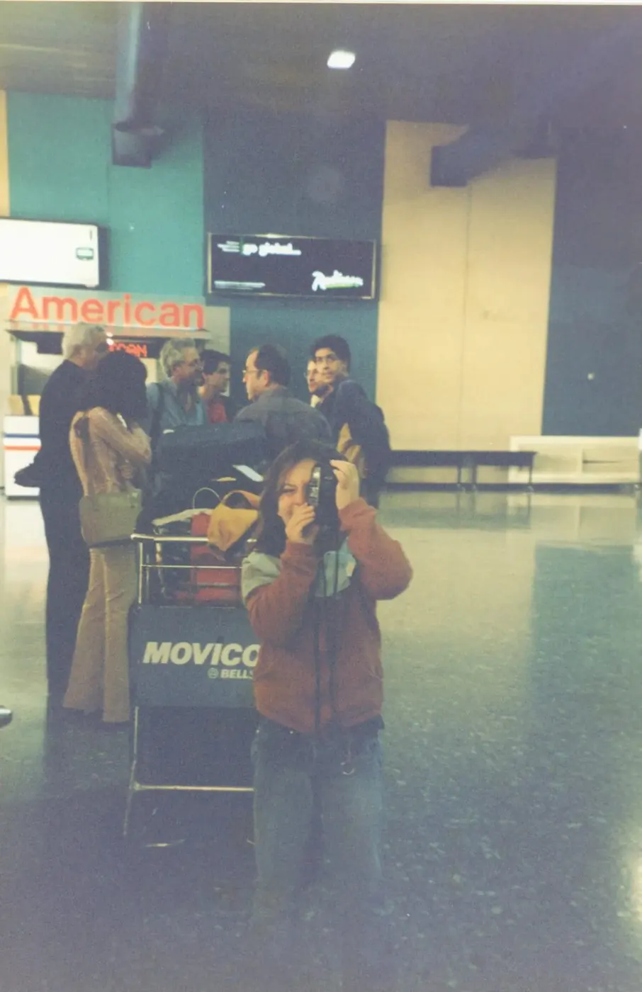 Jessica con una macchina fotografica al banco dell'aeroporto
