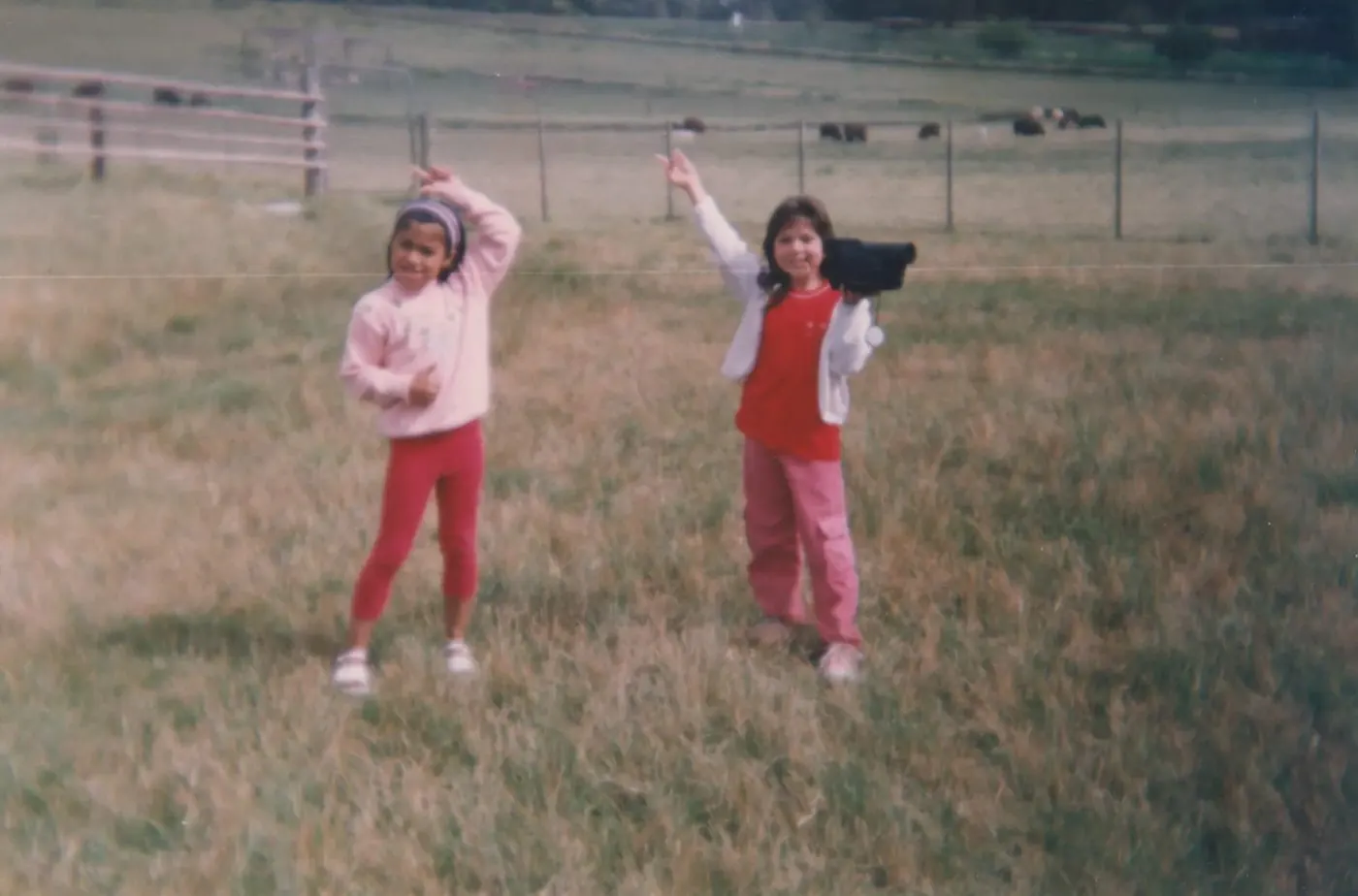 Due bambine in un campo, una con una videocamera